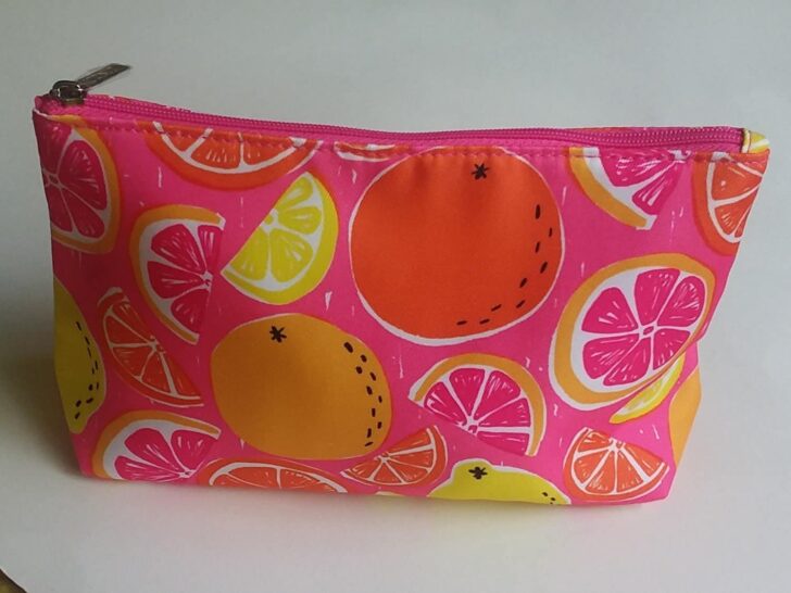 picture of cosmetic bag its hot pink with citrus fruits on it. to be used as an emergency period kit
