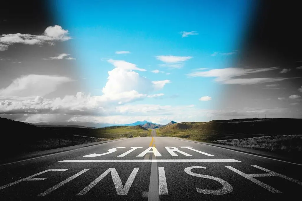 road stretching to the horizon, blue sky. words start and finish painted on road