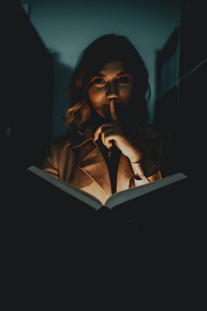 woman in library with books shushing