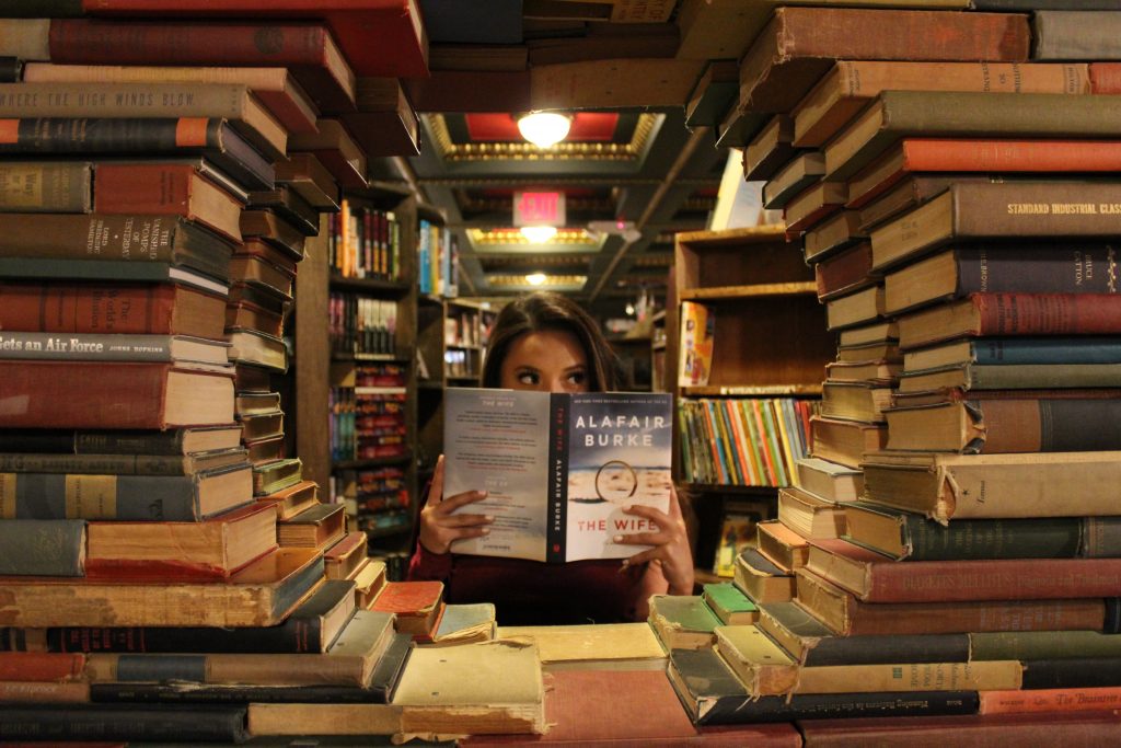 books piled into circular pattern with girl in center