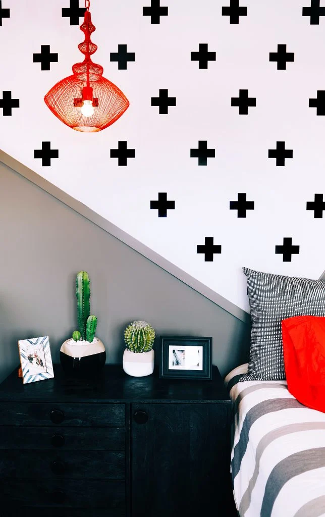 bed with nightstand white wall with black plus signs