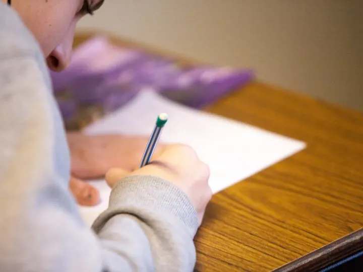 person sitting at desk writing