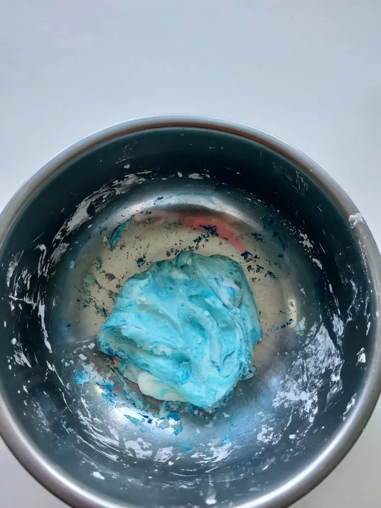 blue homemade slime in a metal bowl