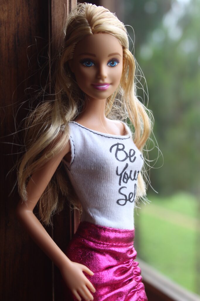 barbie doll wearing shirt saying "be yourself"