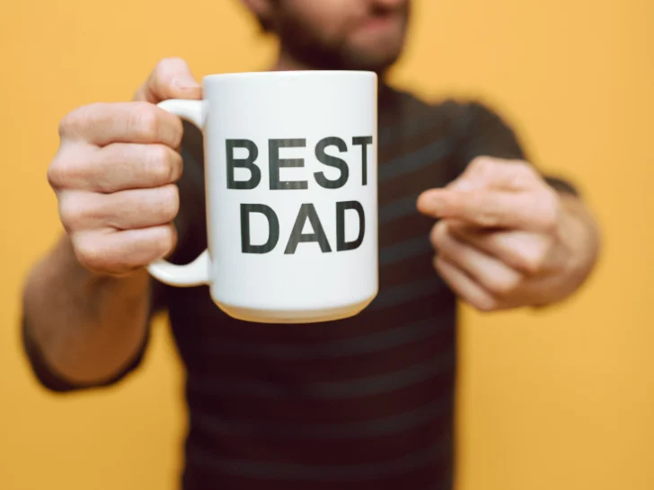 man holding and pointing to a mug saying best dad gifts for dad