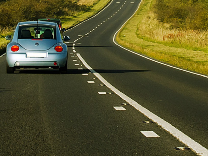 car driving down winding highway