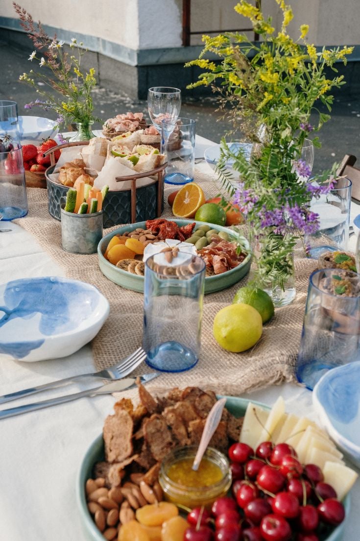 table decorated with place settings, flowers, fruit, cheese, nut platter, Brunch Ideas That’ll Make You the MVP of Mid-Morning Meals