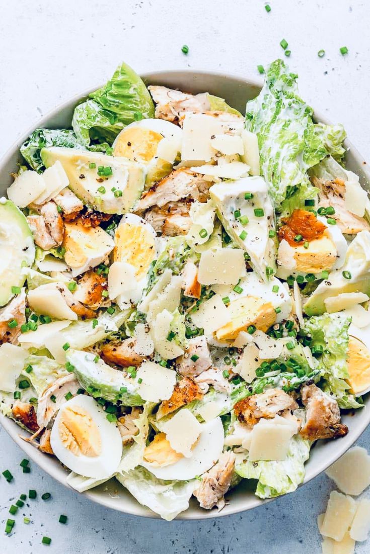 salad with romaine lettuce, avocado, hard boiled eggs, chicken, cheese in a bowl. summer salad ideas
