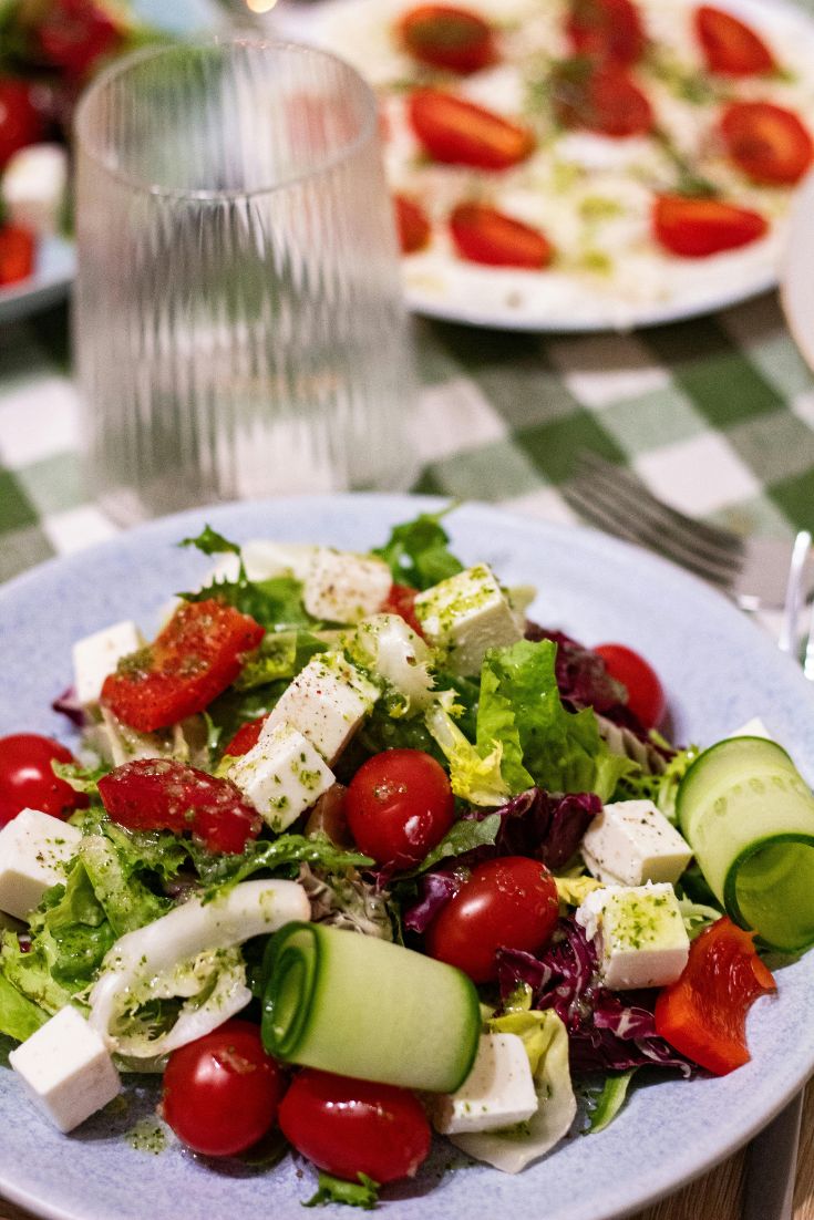 salad greens, feta, rolled cucumbers, cherry tomatos, in a bowl